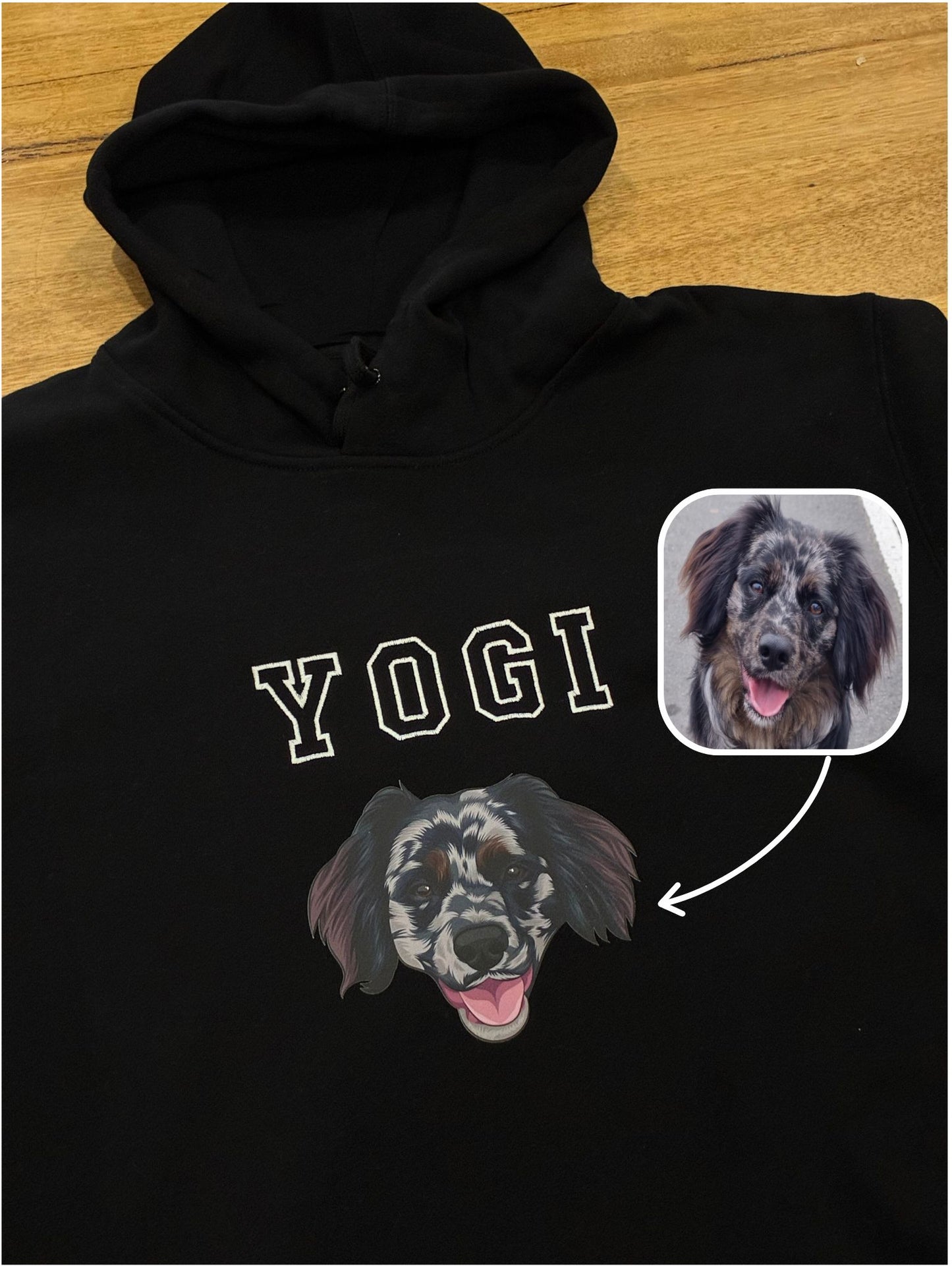Black hoodie with 'YOGI' and a dog illustration on a wooden surface